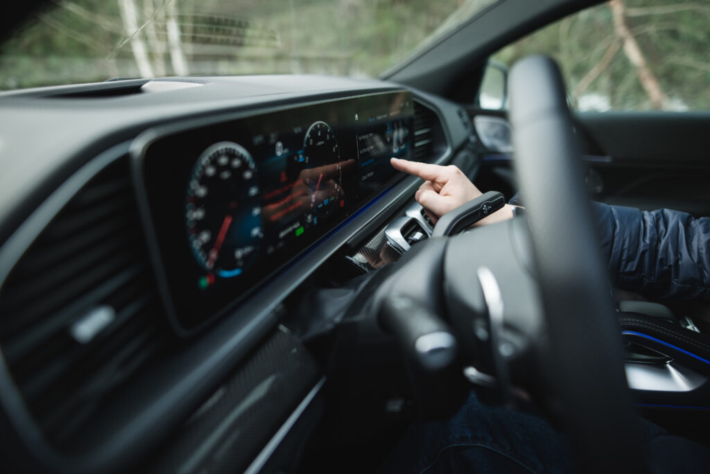 Eine Hand bedient das Amaturenbrett in einem Auto