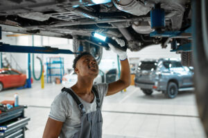 Ein Mechaniker sieht sich den Unterboden eines Autos an