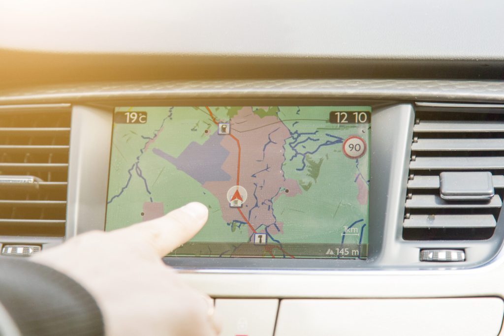 Eine Hand deutet auf ein Navigationssystem mit dem aktuellen Standort