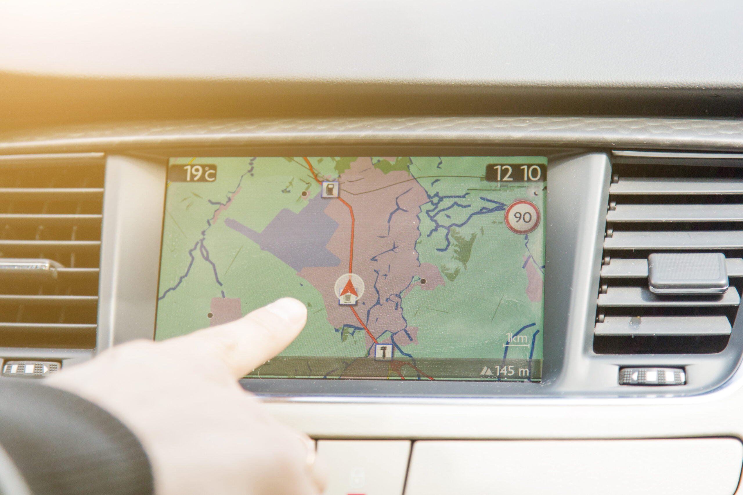 Eine Hand deutet auf ein Navigationssystem mit dem aktuellen Standort