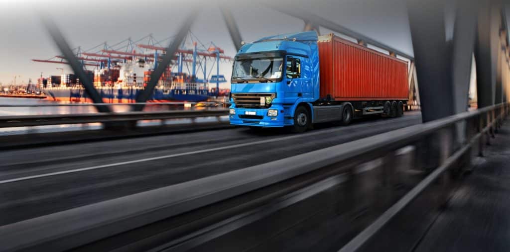 Roter LKW überquert eine Autobahnbrücke