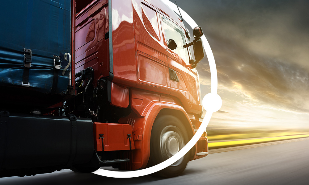 Roter LKW fährt richtung Sonnenuntergang