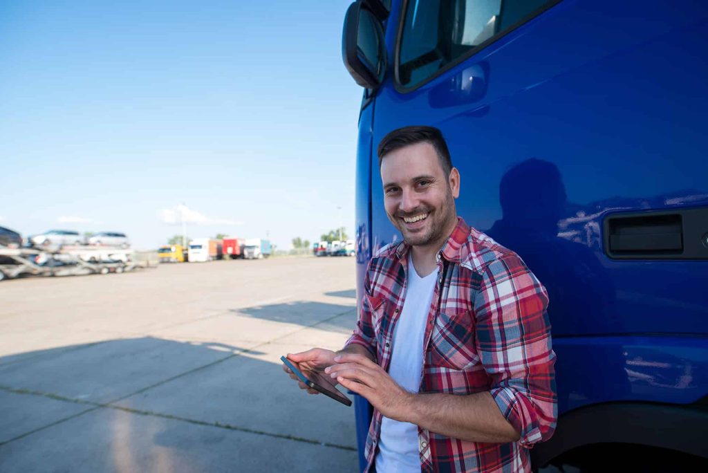 Mann vor blauem LKW lächelnd